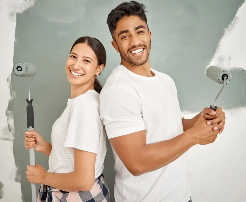 A Tricoat specialist applying a light blue textured paint finish with a roller, showcasing our professional texture painting service in Singapore.